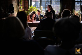 The bride signs the marriage documents during the ceremony at Kelham Island in Sheffield, marking an official and meaningful step forward for the couple today.